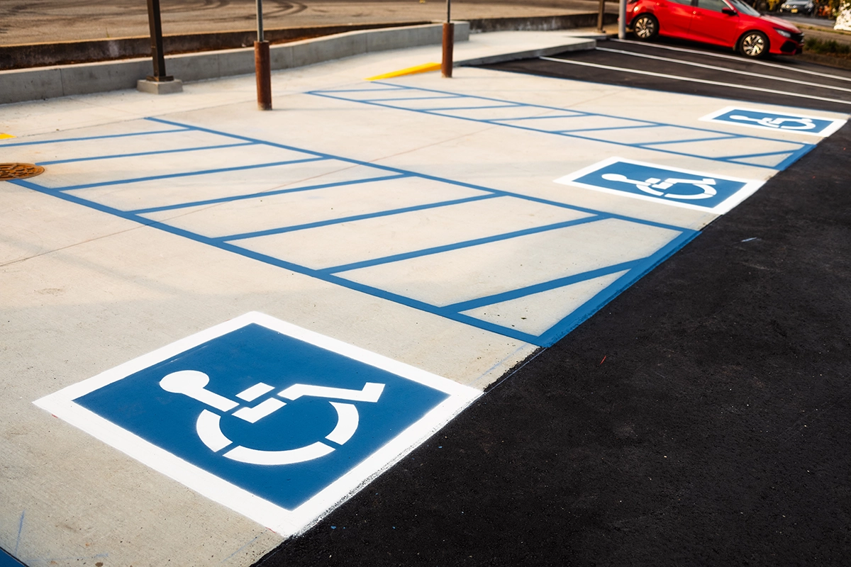 ADA accessible parking stall with blue pavement markings and access aisle